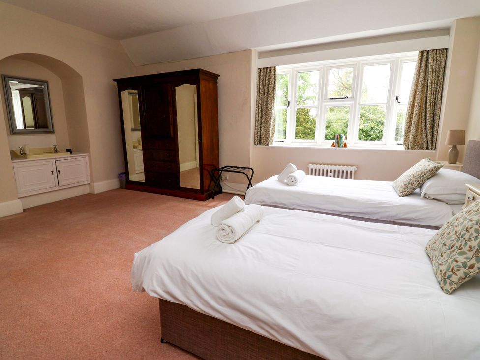 A bedroom with two beds and a wardrobe at Parkfields House Stoke-on-Trent