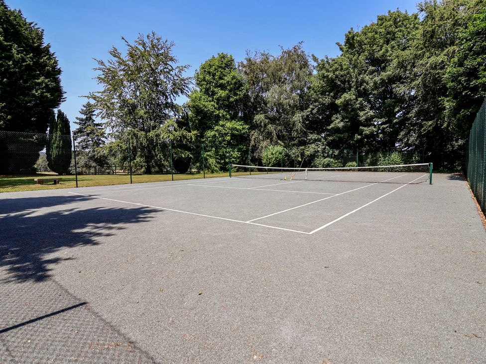 A tennis court surrounded by trees at Parkfields House Tittensor near Barlaston