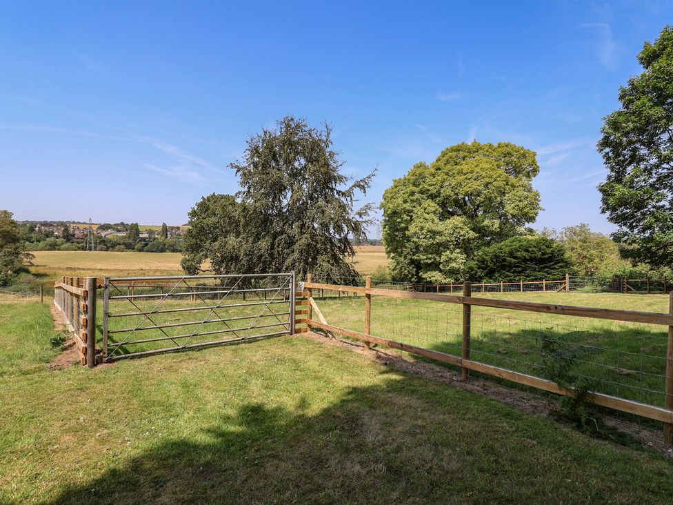A fenced area with a gate and trees at Parkfields House in Tittensor near Barlaston