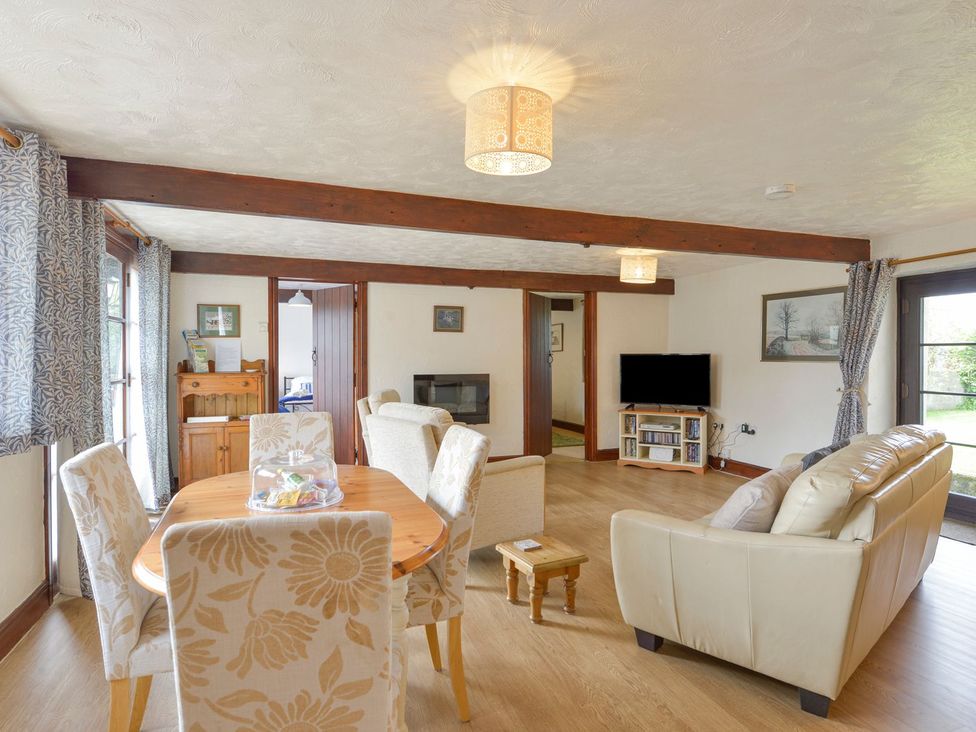 A living room with a dining table and sofa at Pillhead Cart Linhay in Bideford