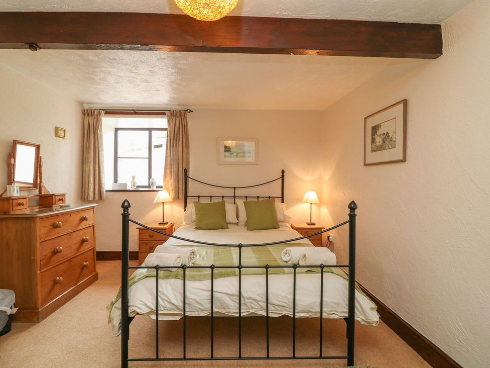 A bedroom with a bed and wooden dresser at Pillhead Cart Linhay Bideford