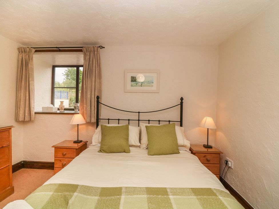 A bedroom with a bed and nightstand at Pillhead Cart Linhay Bideford