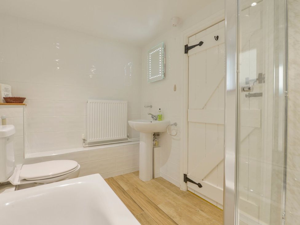 A bathroom with a bathtub, toilet, and sink at Pillhead Cart Linhay in Bideford