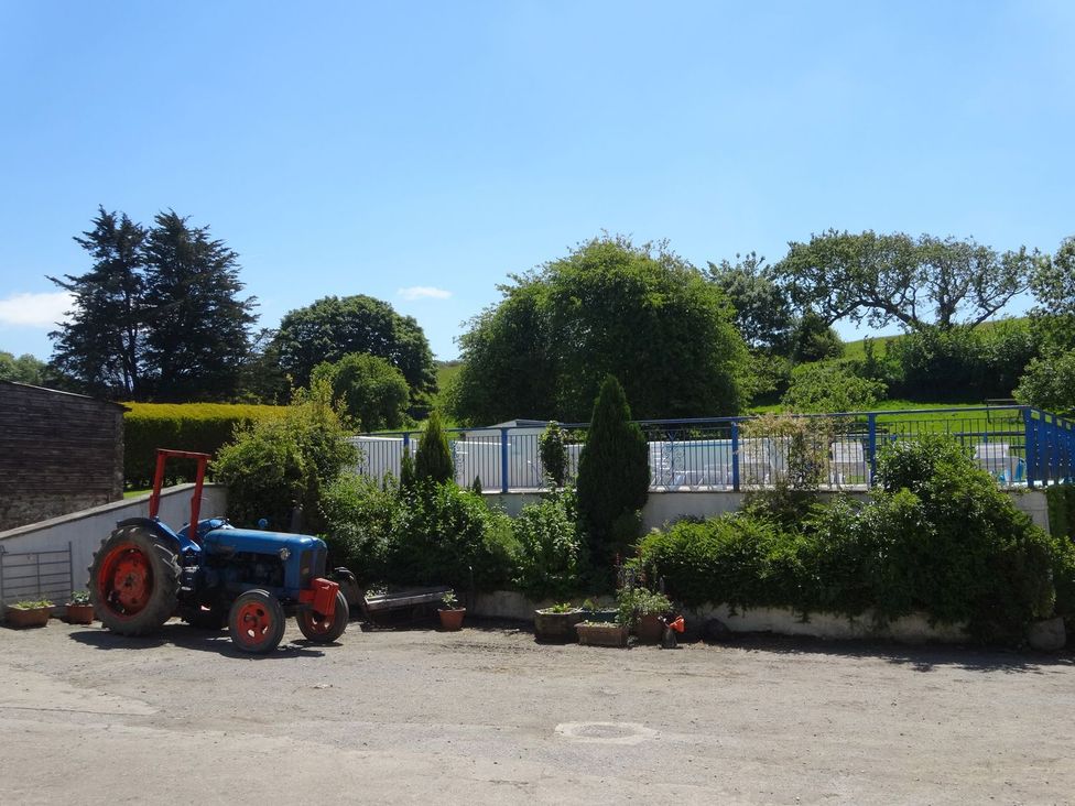 A tractor near a garden area with planters at Pillhead Cart Linhay Bideford