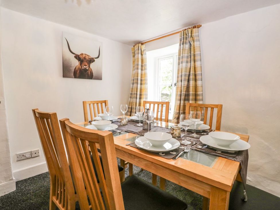 A dining room with a wooden table and chairs at Brigg House Broughton-in-Furness