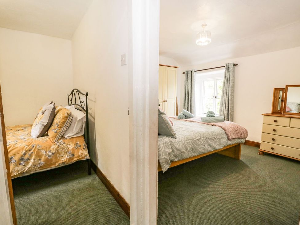 A bedroom with two beds and storage at Brigg House, Broughton-in-Furness
