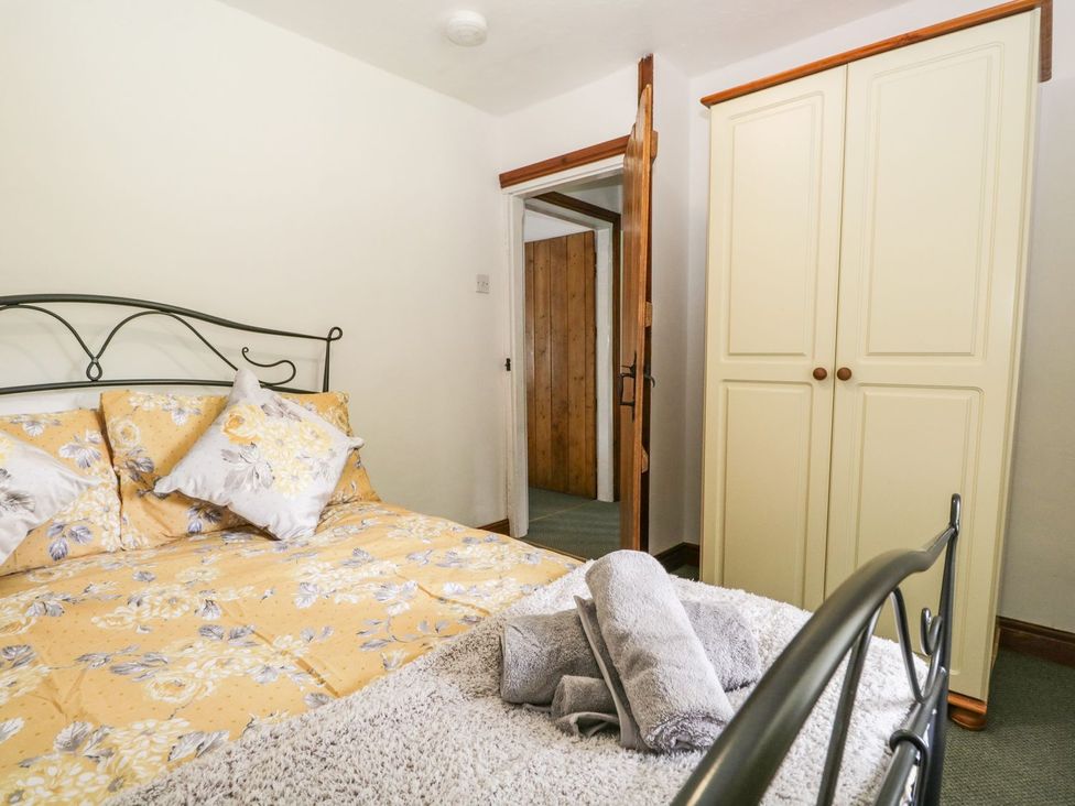 A bedroom with a bed and wardrobe at Brigg House Broughton-in-Furness