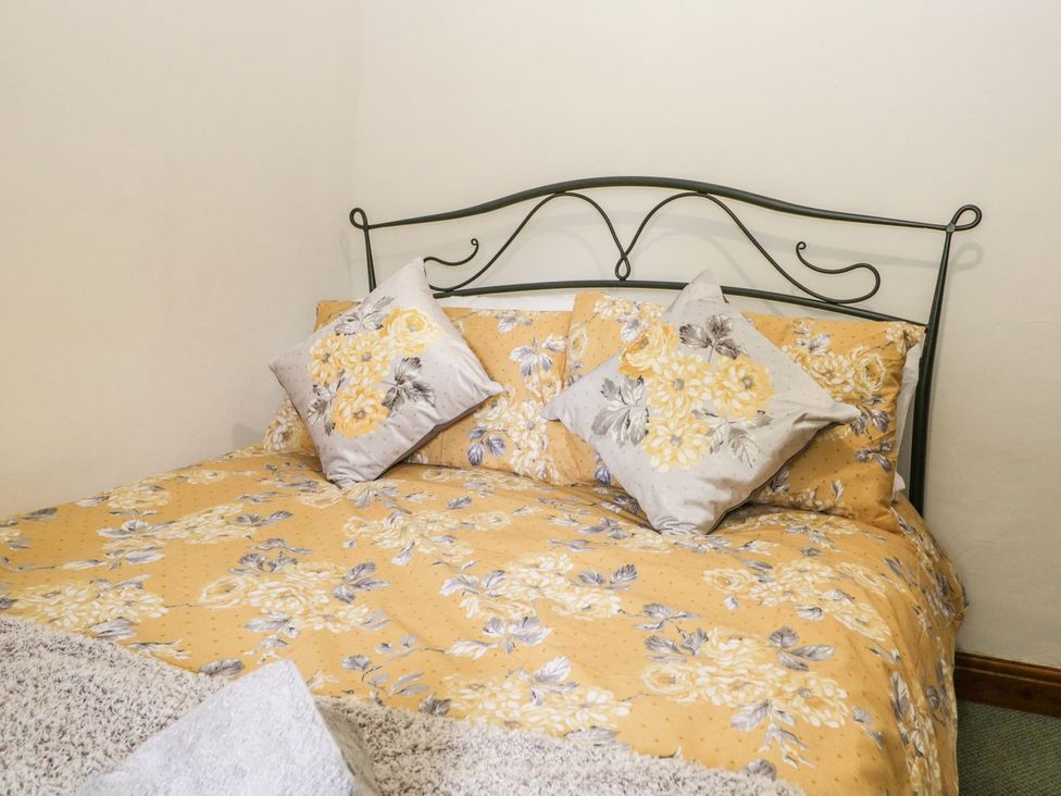 A bed with decorative pillows at Brigg House in Broughton-in-Furness