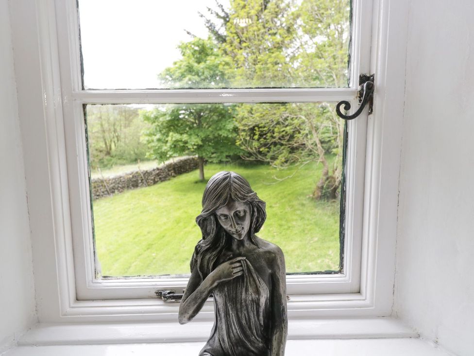 A window with a statue overlooking a garden at Brigg House in Broughton-in-Furness