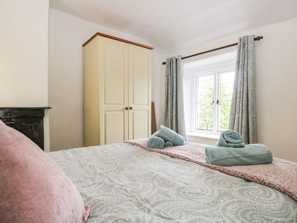 A bedroom with a bed and a wardrobe at Brigg House in Broughton-in-Furness