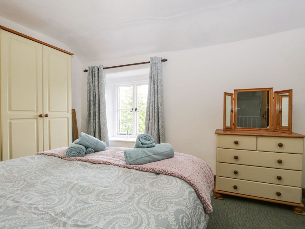 A bedroom with a bed and wardrobe at Brigg House in Broughton-in-Furness