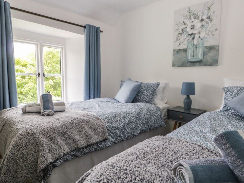 A bedroom with two beds and a nightstand at Brigg House in Broughton-in-Furness