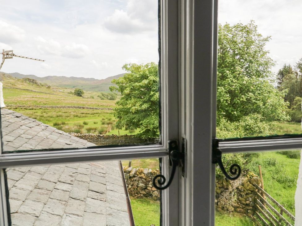 A view from a window showing trees and hills at Brigg House in Broughton-in-Furness