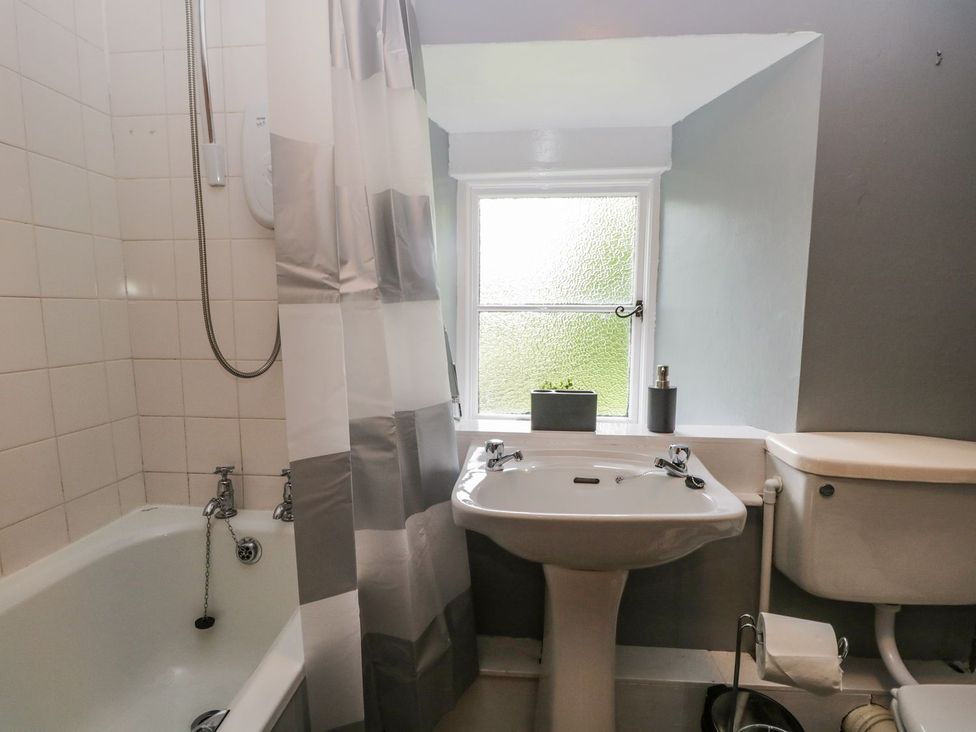 A bathroom with a bathtub, sink, and toilet at Brigg House in Broughton-in-Furness