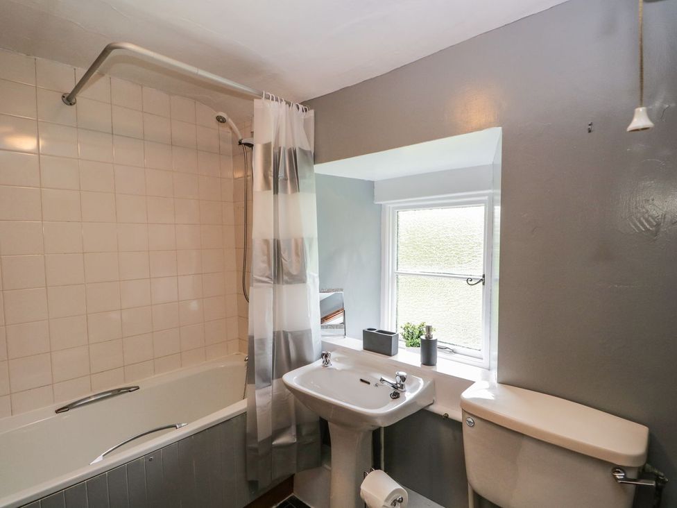 A bathroom with a bathtub, sink, and toilet at Brigg House in Broughton-in-Furness