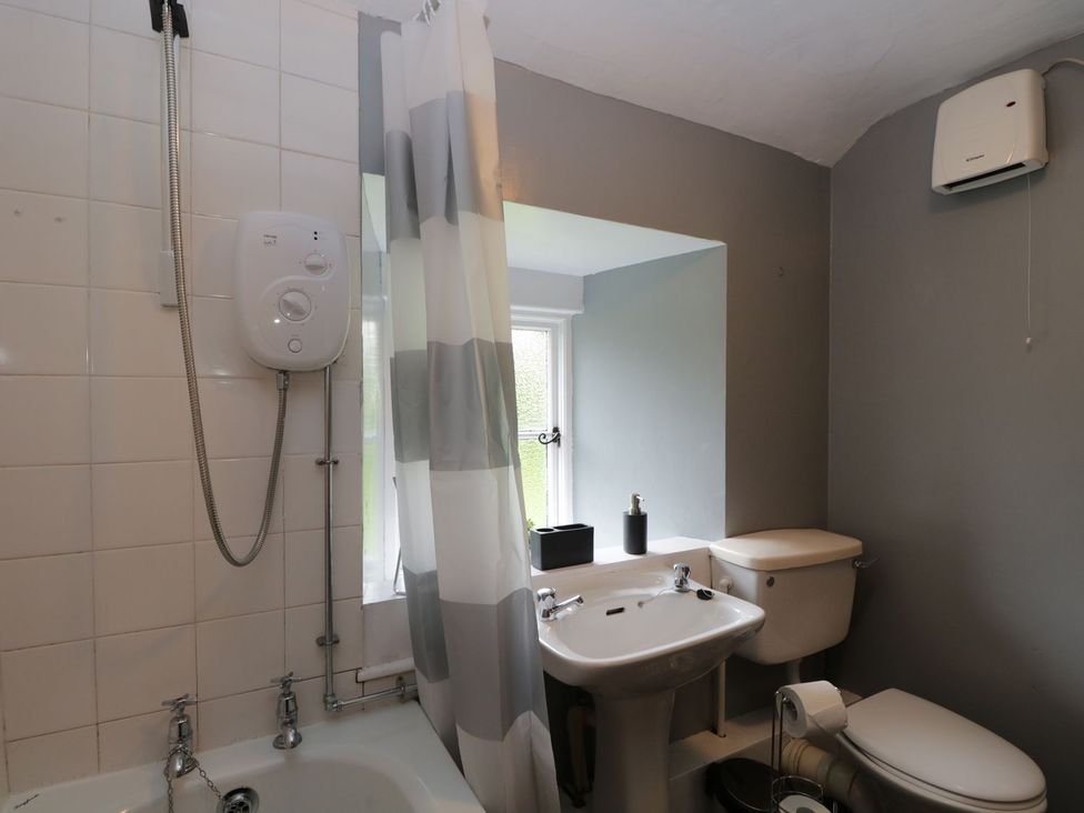 A bathroom with a bathtub, shower, sink and toilet at Brigg House in Broughton-in-Furness
