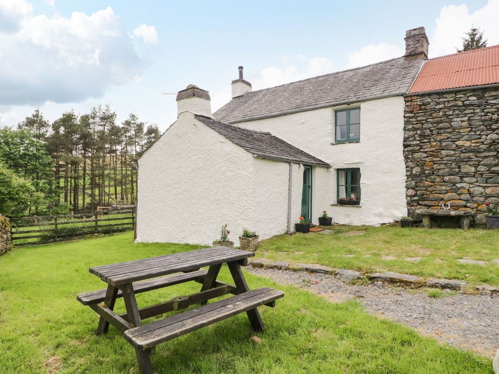 A cottage with table and chairs in the garden at Brigg House in Broughton-in-Furness