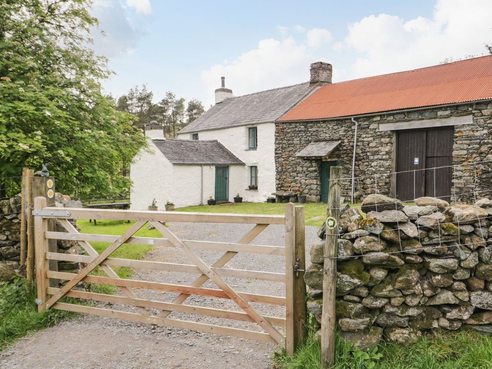 An outdoor view of a house with a gate and stone wall at Brigg House in Broughton-in-Furness