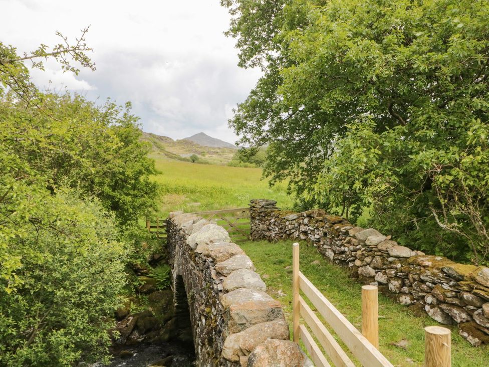 A stone bridge over water surrounded by greenery at Brigg House Broughton-in-Furness