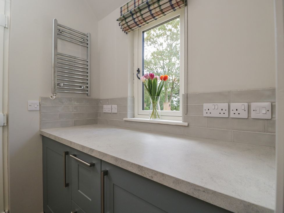 A kitchen with a window and flowers at Foxglove in Stratton Audley near Bicester