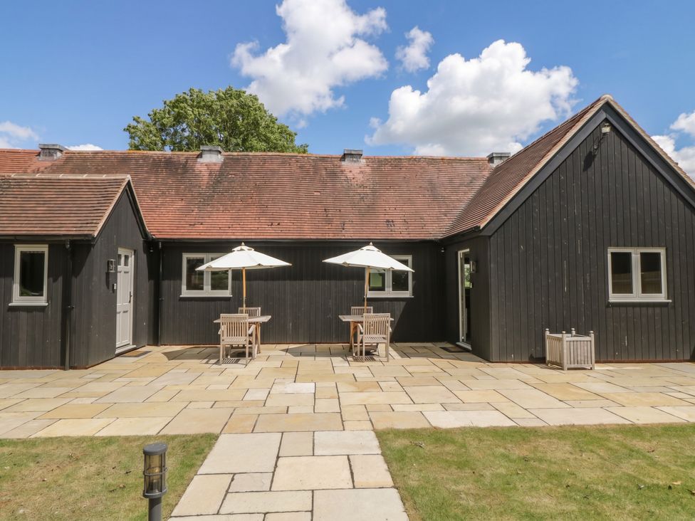 A house with patio furniture and umbrellas at Foxglove in Stratton Audley near Bicester