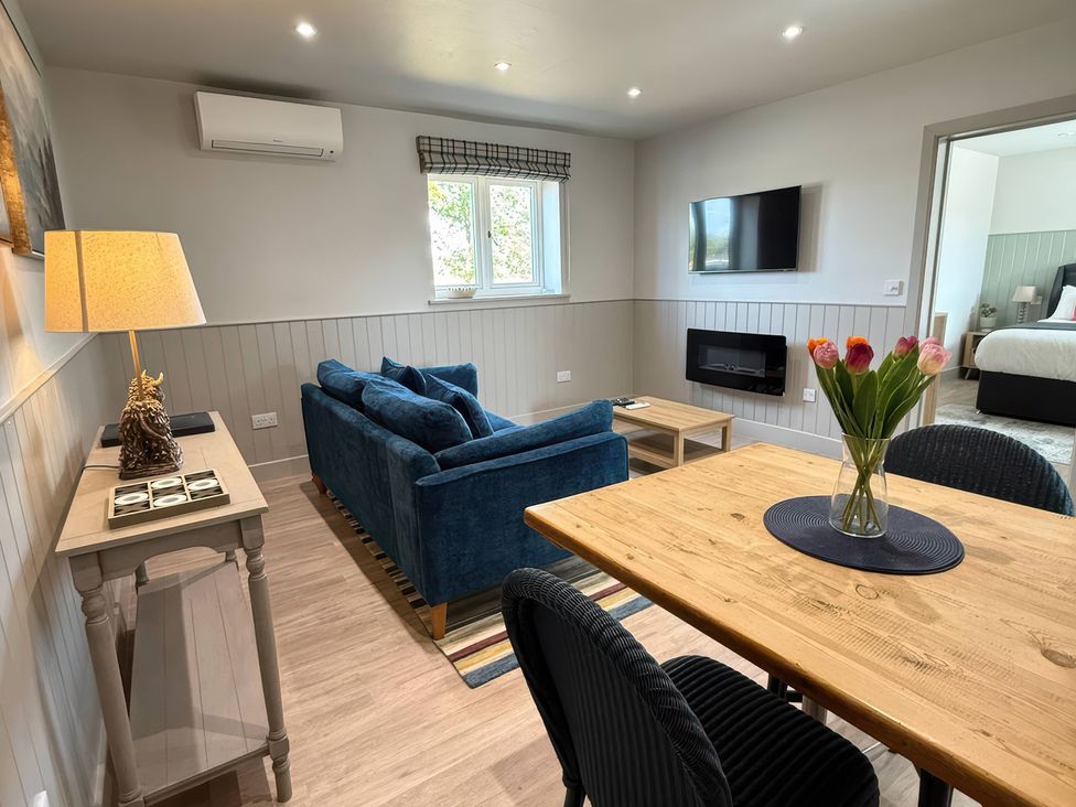 A living room with a sofa and dining table at Foxglove in Stratton Audley near Bicester