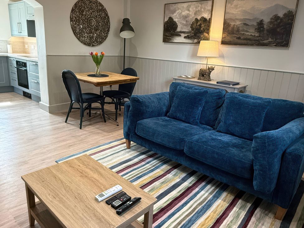 A living room with a sofa, table, and chairs at Foxglove in Stratton Audley near Bicester