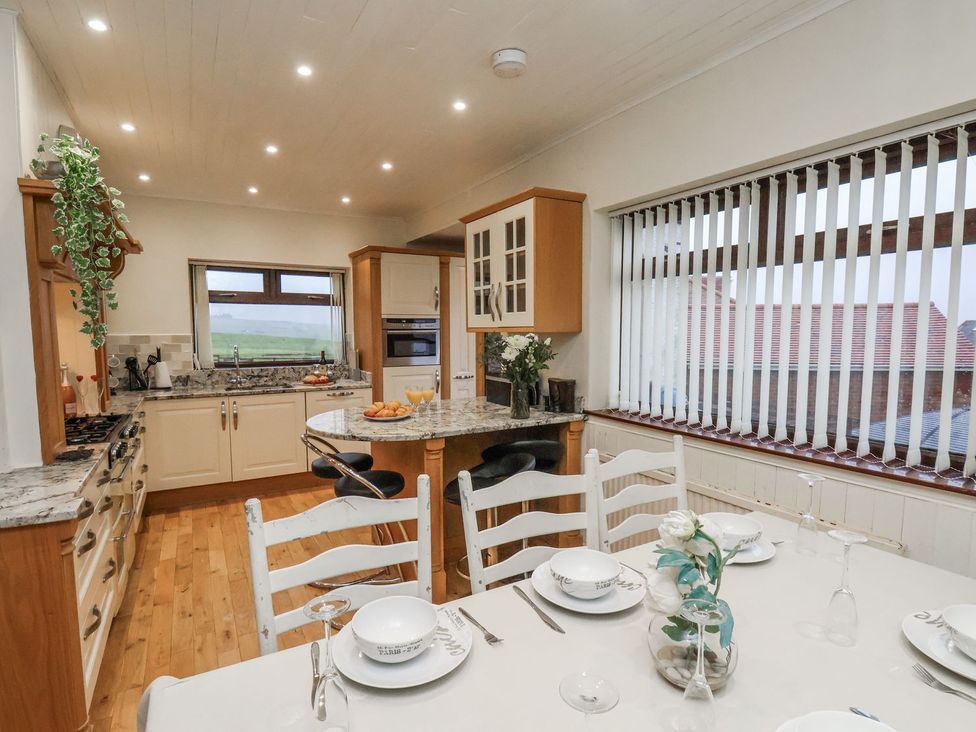 A kitchen with wood flooring and a dining table at Beachcrest in Whitby