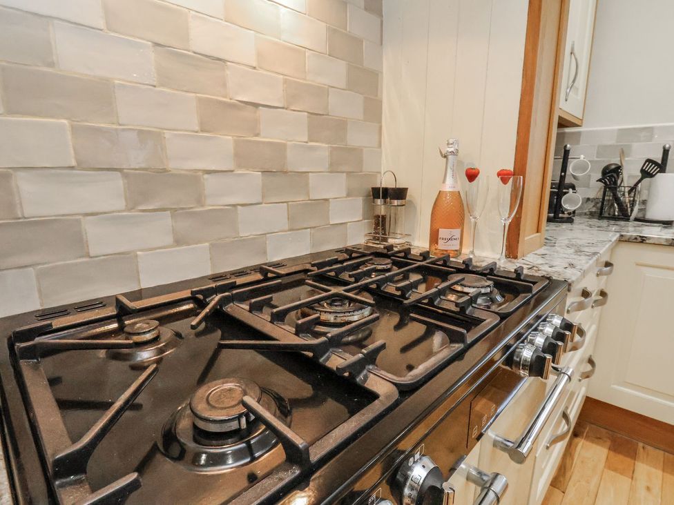 A kitchen with a gas stove and champagne glasses at Beachcrest in Whitby