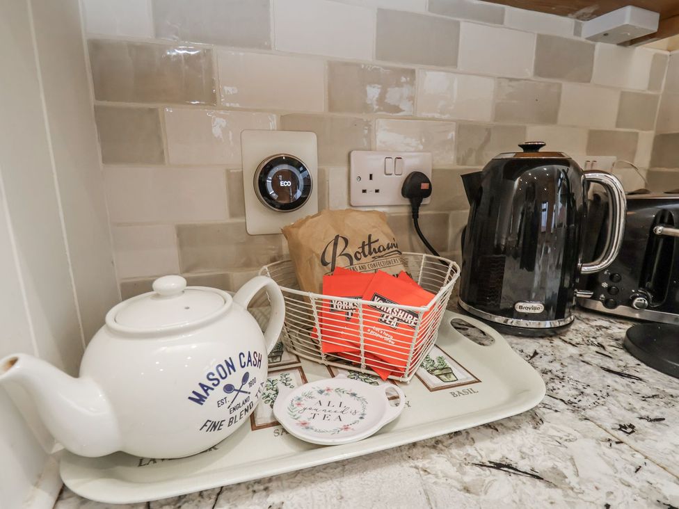 A kitchen countertop with a teapot kettle and tea bags at Beachcrest in Whitby