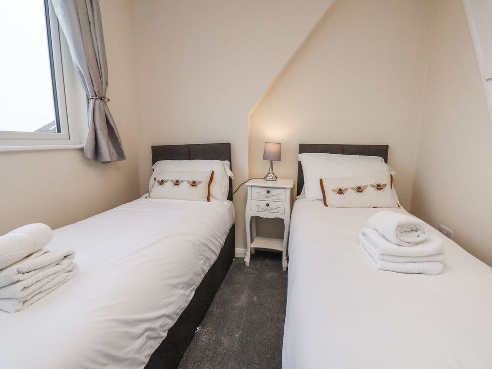 A bedroom with two single beds and a bedside table at Beachcrest in Whitby