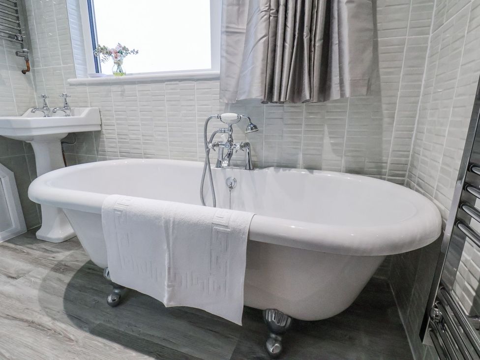 A bathtub with a faucet and a sink at Beachcrest in Whitby