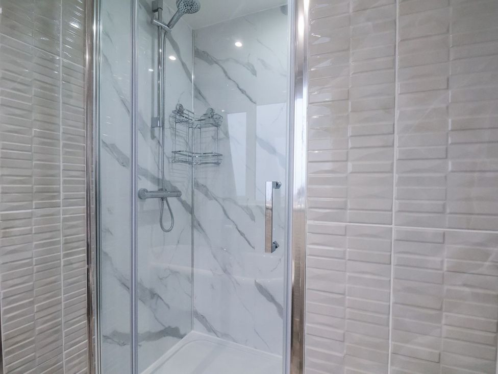 A shower with glass door and tiles in Beachcrest Whitby