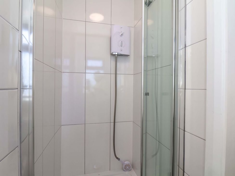 A shower with glass door and water control unit at Beachcrest in Whitby