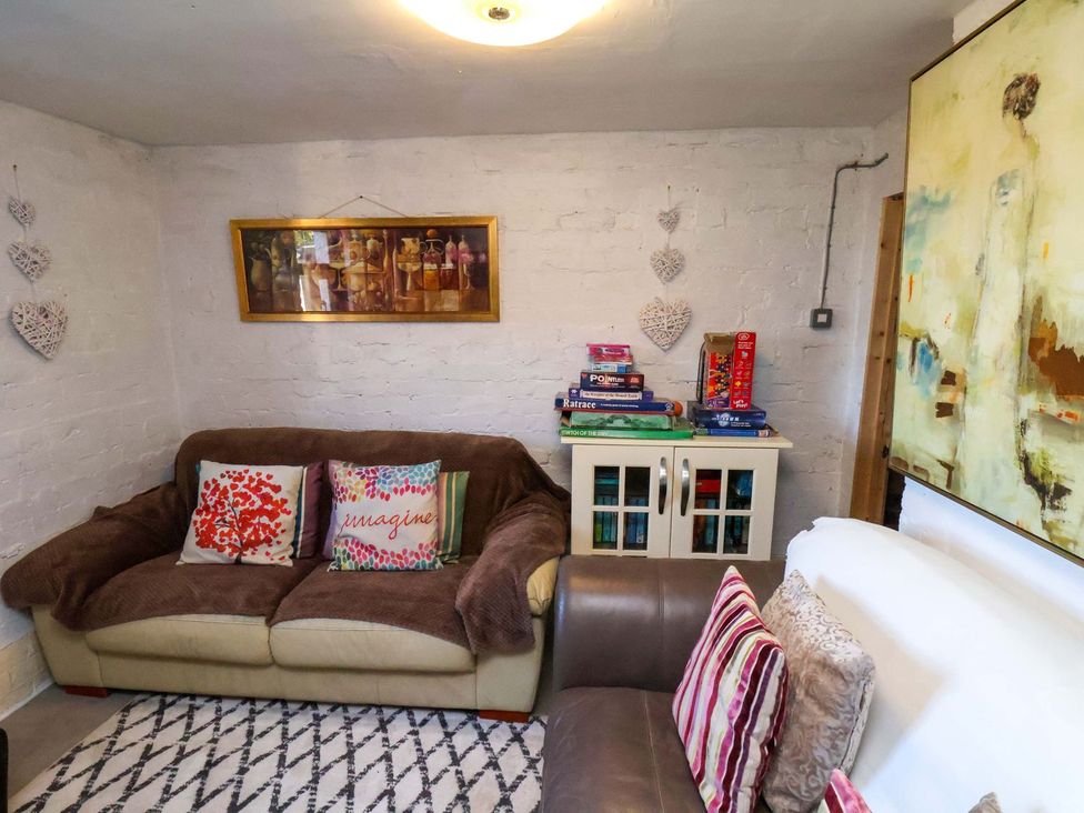 A living room with a sofa and books on a shelf at Beachcrest in Whitby