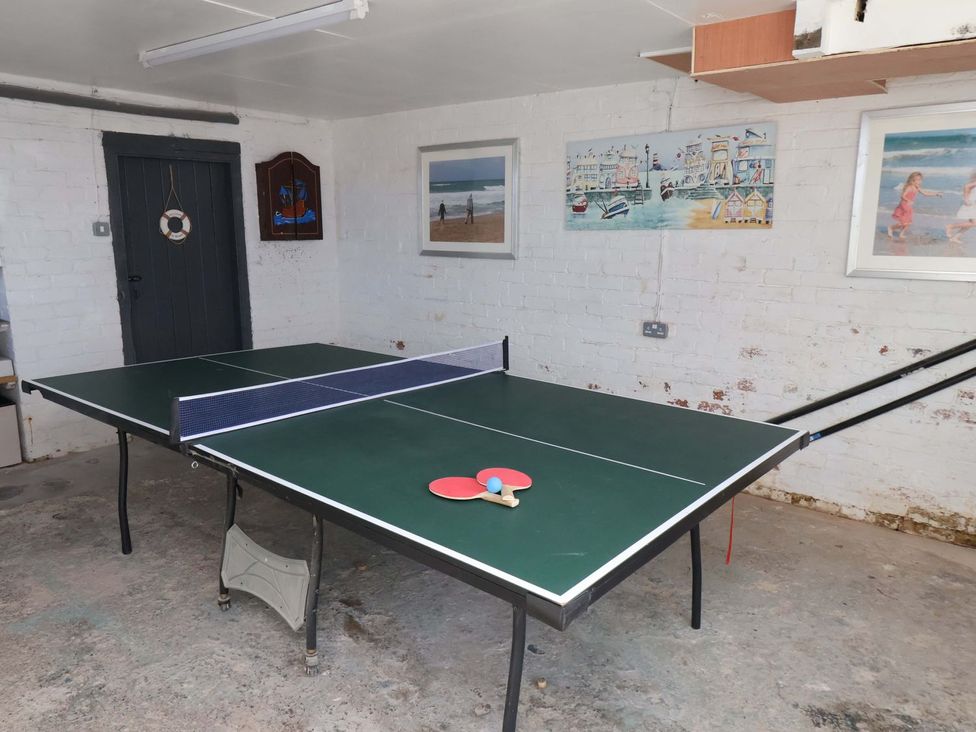 A table tennis table with paddle and ball in a game room at Beachcrest in Whitby