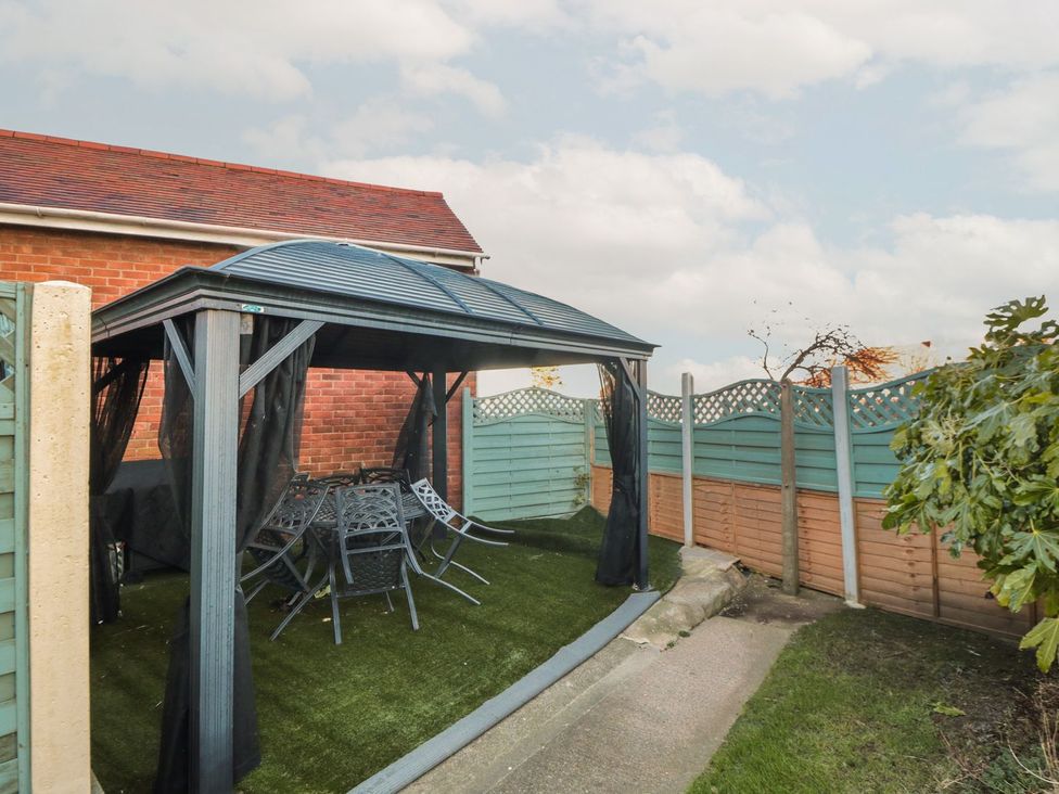 A gazebo with a garden table and chairs at Beachcrest in Whitby