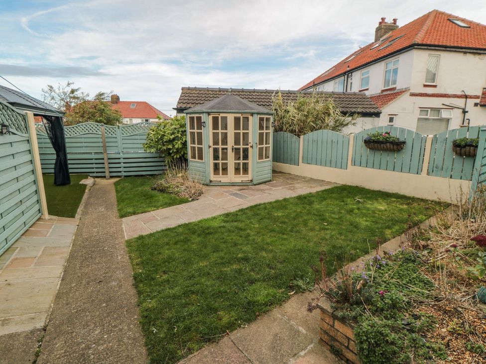 A garden with a shed and pathways at Beachcrest in Whitby