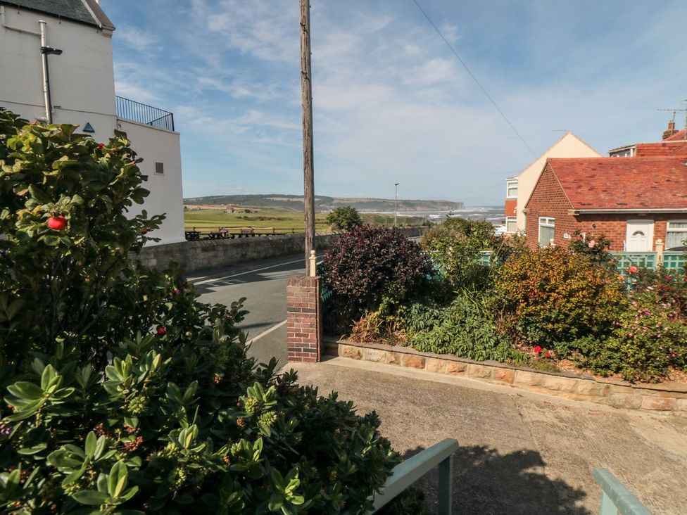 A view of a garden and road with houses in the background at Beachcrest in Whitby