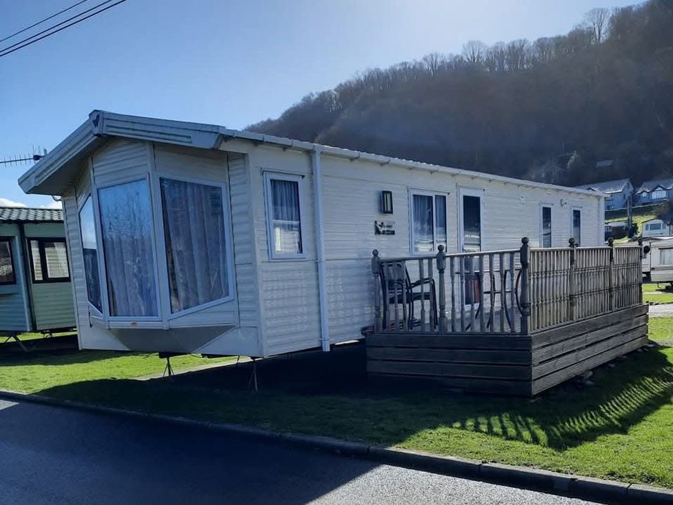 A caravan with a deck and mountain view at Clarach Bay Holiday Village W18 Aberystwyth