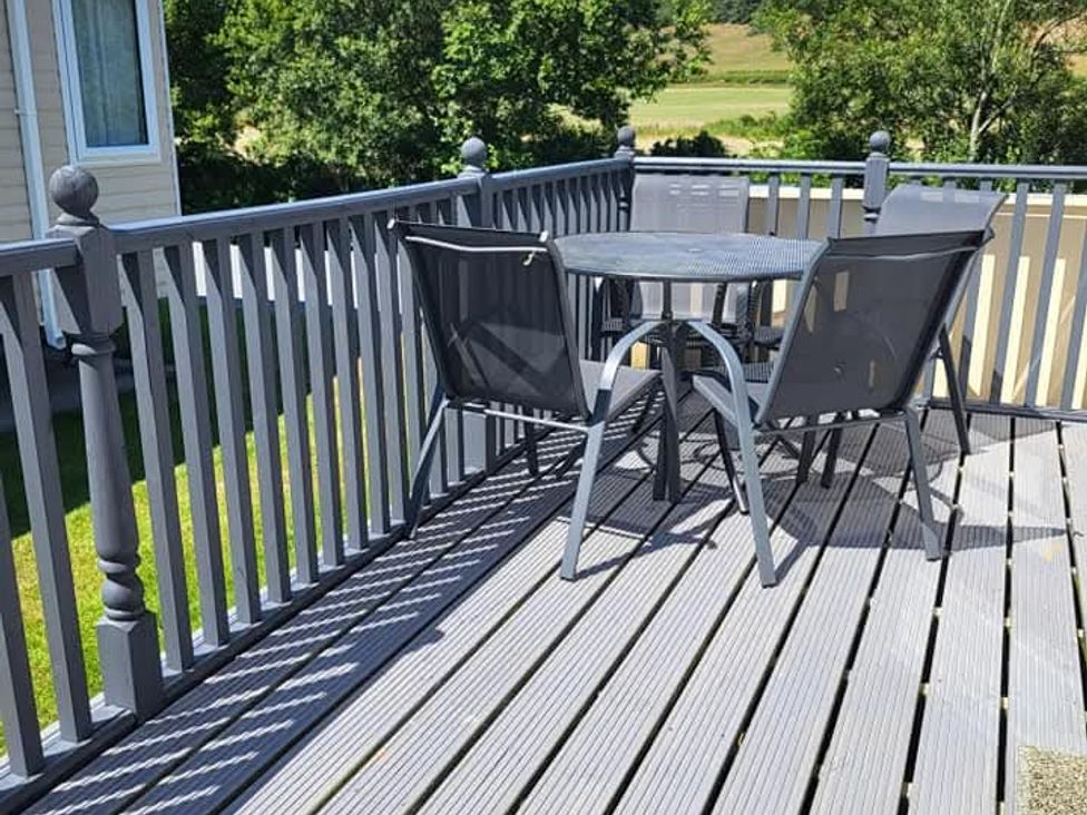A deck with a table and chairs at Clarach Bay Holiday Village W18 Aberystwyth