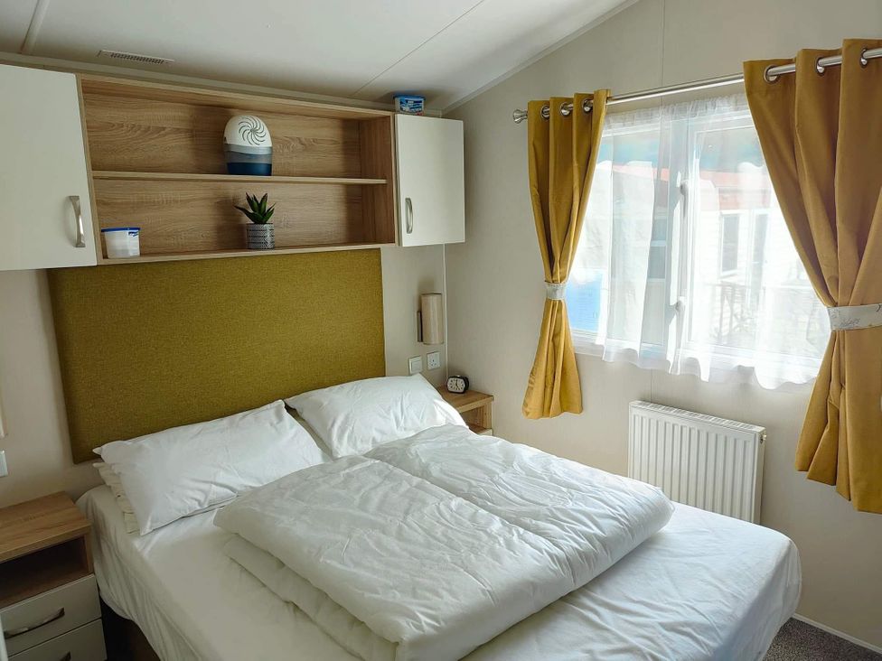A bedroom with a bed and shelves at Clarach Bay Holiday Village W18 Aberystwyth