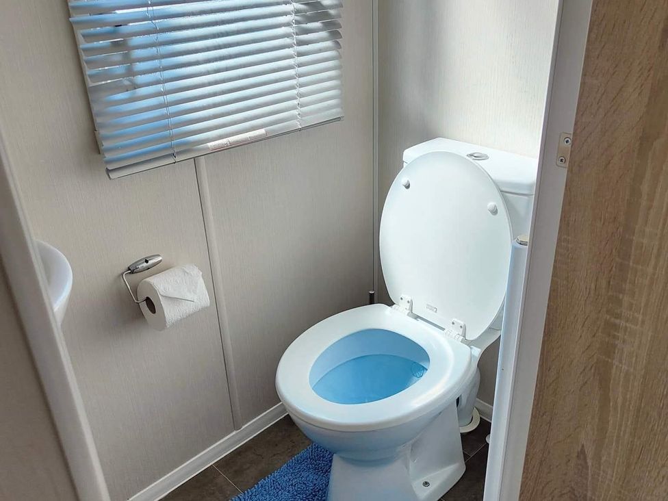 A toilet with a roll of toilet paper at Clarach Bay Holiday Village W18 Aberystwyth