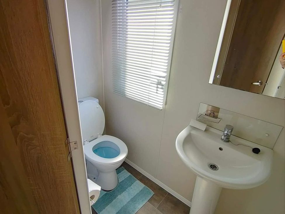 A bathroom with a toilet and sink at Clarach Bay Holiday Village W18 Aberystwyth