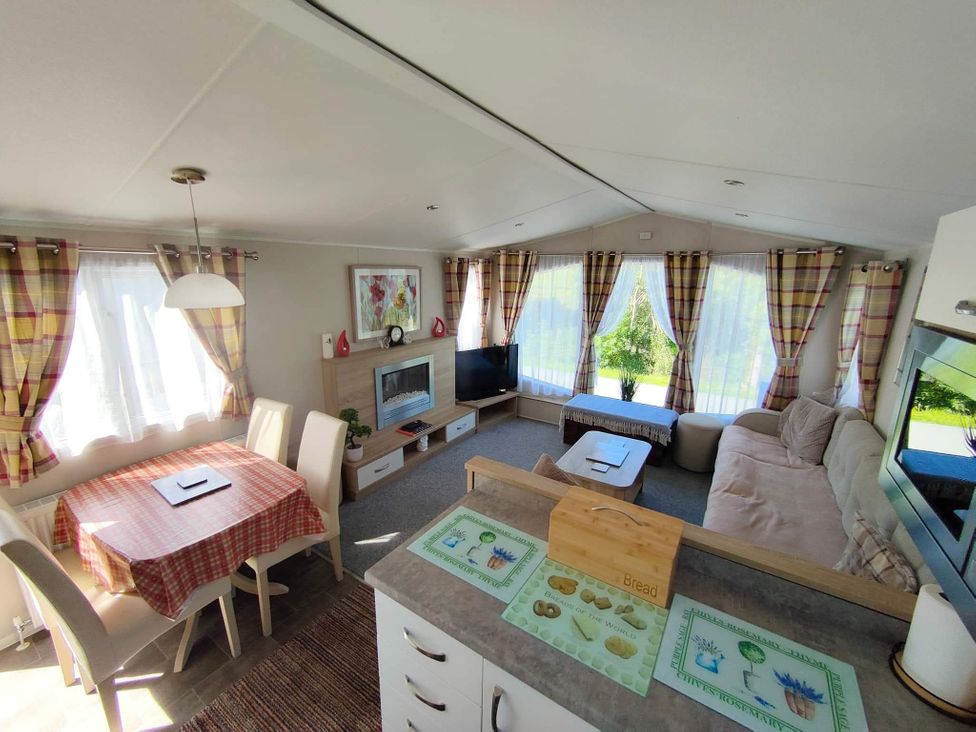 A living room with a television and sofa at Clarach Bay Holiday Village W18 Aberystwyth