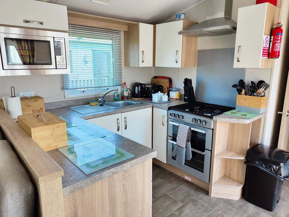 A kitchen with appliances and cabinets at Clarach Bay Holiday Village W18 Aberystwyth
