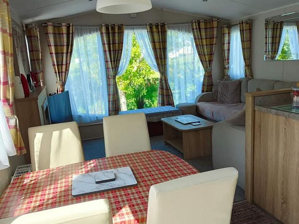 A living room with a dining table and sofa at Clarach Bay Holiday Village W18 Aberystwyth