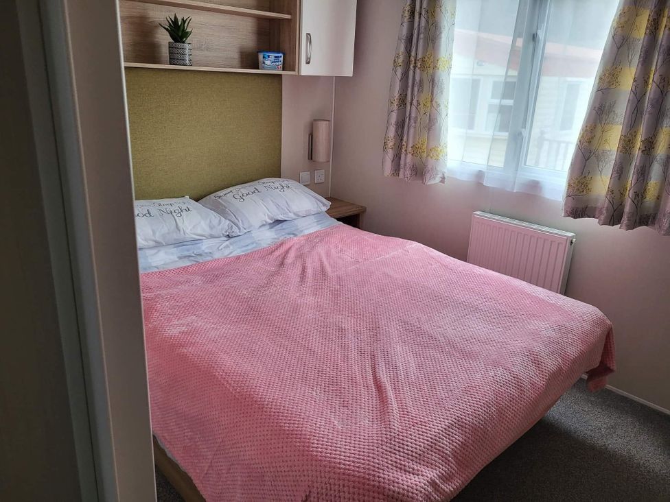 A bedroom with a bed and shelves at Clarach Bay Holiday Village W18 in Aberystwyth