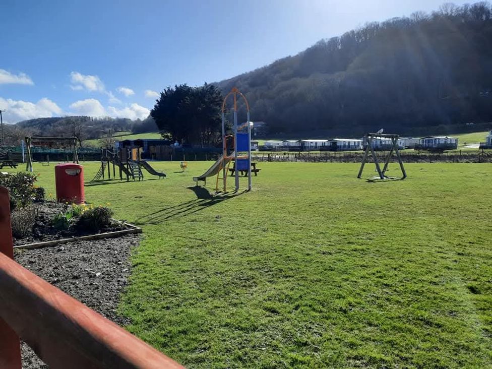 A playground with slides and swings at Clarach Bay Holiday Village W18 in Aberystwyth