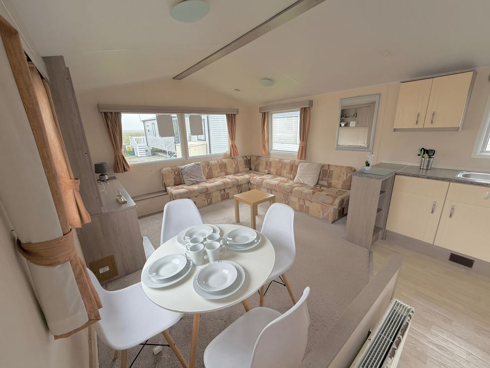 A living room with a sofa and dining area at Holiday Park Seawick in Clacton-on-Sea
